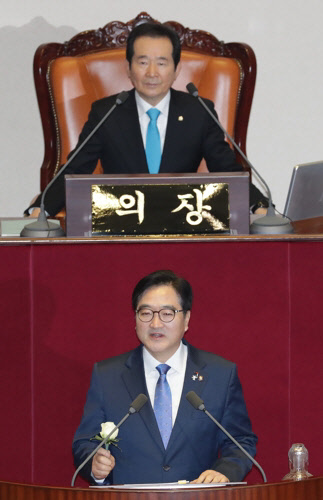 우원식 민주당 원내대표가 31일 국회 본회의에서 교섭단체 대표연설을 하고 있다. 우 원내대표는 대표연설에 앞서 하얀 장미를 들고 성추행 피해를 폭로한 서지현 검사를 응원했다. /연합뉴스